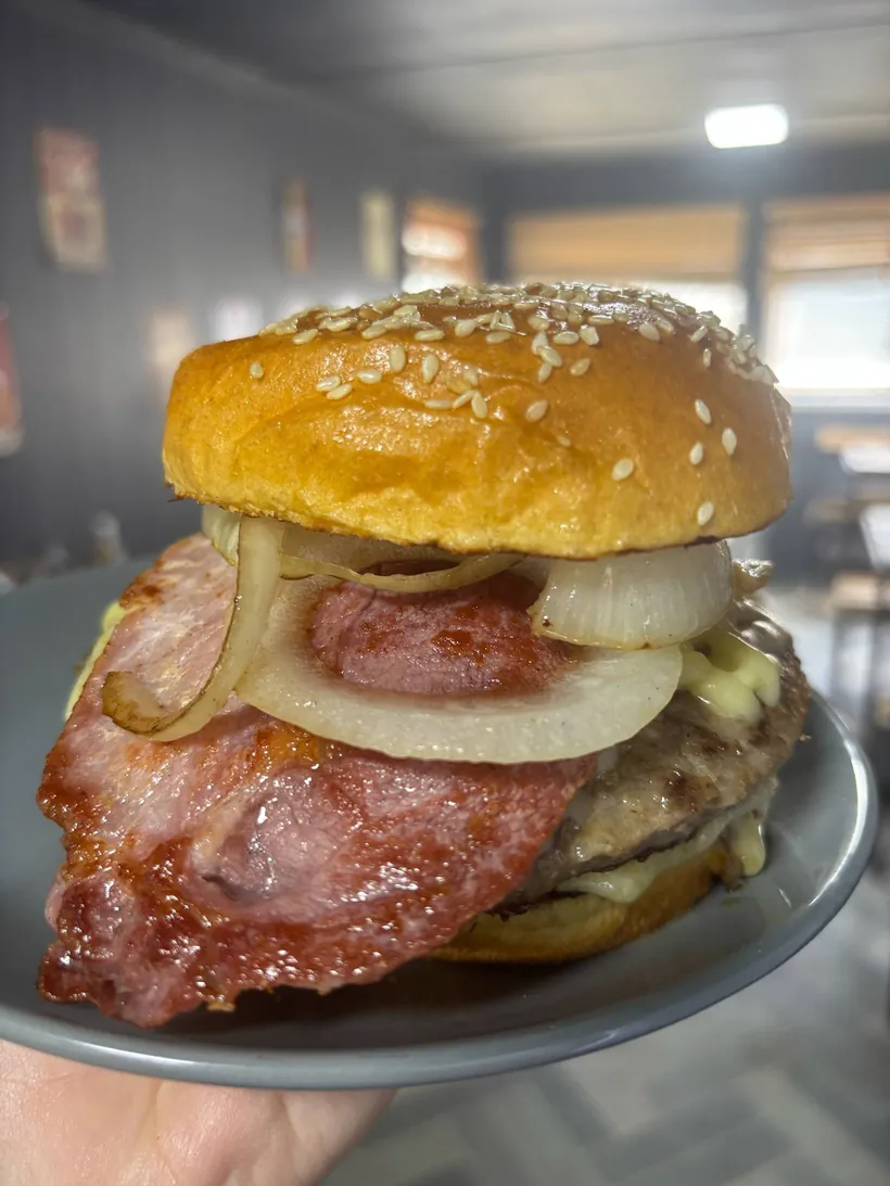 Barney's bacon and onion stack burger on a sesame bun, served in the café